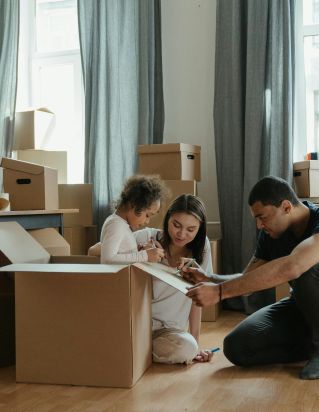 A family unpacks moving boxes in their new home kitchen, creating a cozy atmosphere.